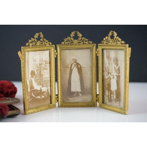 421 - A Continental gilt metal triptych photograph frame surmounted by laurel leaves, h: 9cm, together wit... 