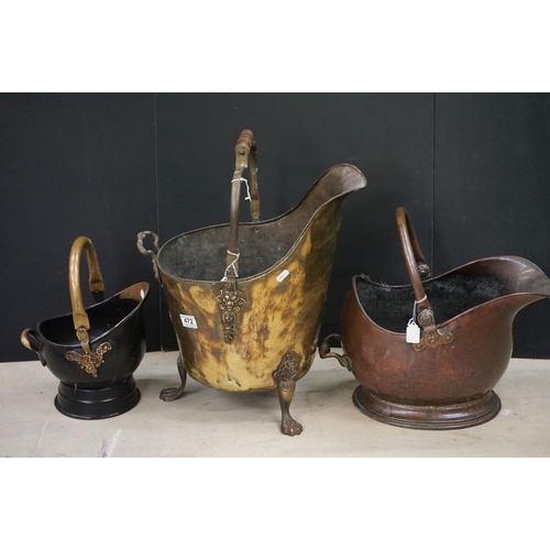 472 - Three coal scuttles to include an antique hammered brass coal scuttle raised on three claw feet, wit... 