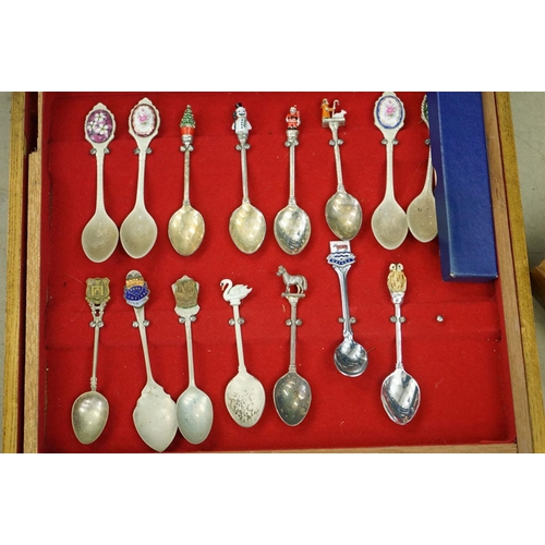 395 - A large collection of mainly silver plated collectors tea spoons contained within six wooden boxes.