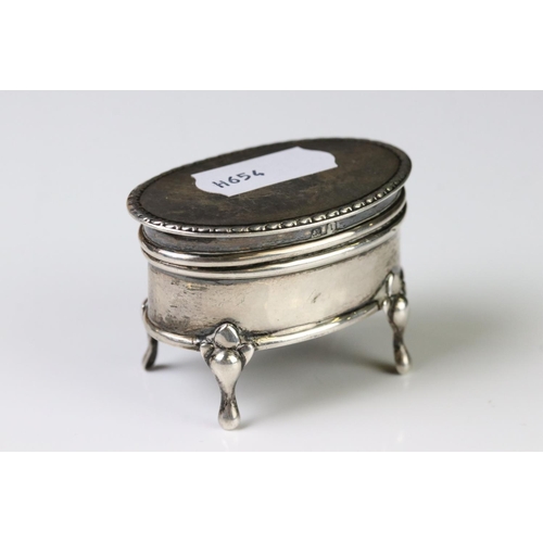 363A - A fully hallmarked sterling silver trinket box set on four feet with hinged lid together with a pair... 