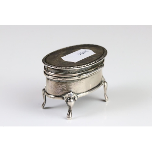 363A - A fully hallmarked sterling silver trinket box set on four feet with hinged lid together with a pair... 