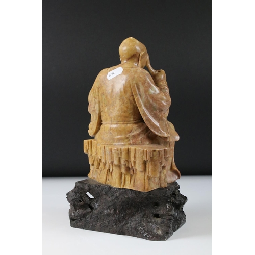 164 - Chinese Soapstone Carving of a Seated Elder, raised on a carved stone base in the form of a rocky ou... 