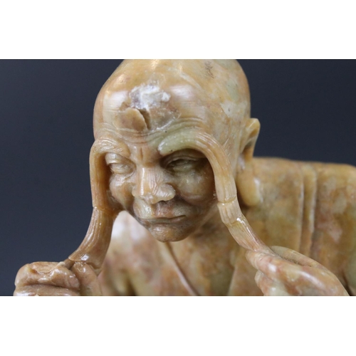 164 - Chinese Soapstone Carving of a Seated Elder, raised on a carved stone base in the form of a rocky ou... 