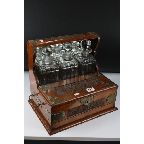 187 - Late 19th century Oak Cased and Brass mounted Tantalus holding three matching cut glass decanters an... 