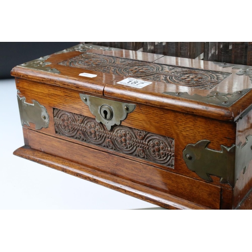 187 - Late 19th century Oak Cased and Brass mounted Tantalus holding three matching cut glass decanters an... 