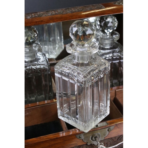 187 - Late 19th century Oak Cased and Brass mounted Tantalus holding three matching cut glass decanters an... 