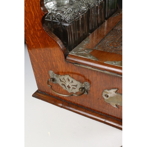 187 - Late 19th century Oak Cased and Brass mounted Tantalus holding three matching cut glass decanters an... 