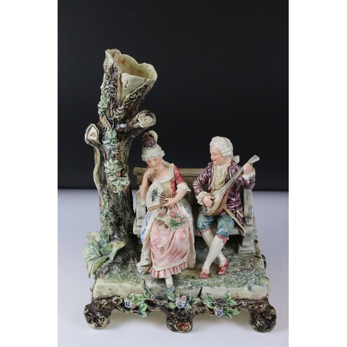 55 - 19th Century porcelain figural spill vase of a 19th Century courting couple on bench with tree, rais... 