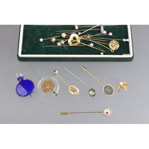 275 - A small collection of tie / cravat pins to include yellow metal and a lucite example.