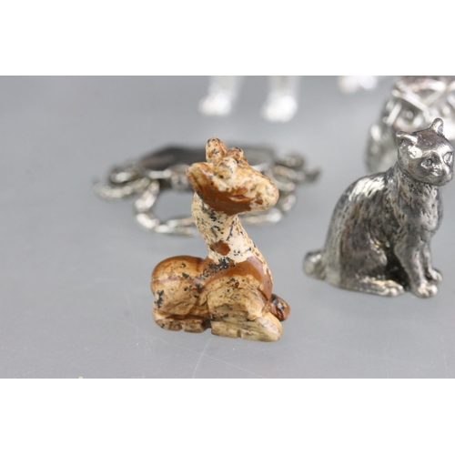 279 - A collection of miniature animal figures to include white metal and stone examples.