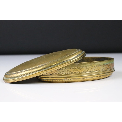 292 - An antique 18th century oval brass snuff box with ornate chased decoration.