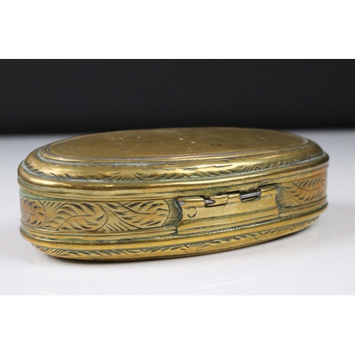 292 - An antique 18th century oval brass snuff box with ornate chased decoration.