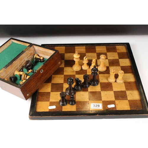 329 - A wooden chess set, in the style of Staunton, within a wooden box together with a wooden chess board... 