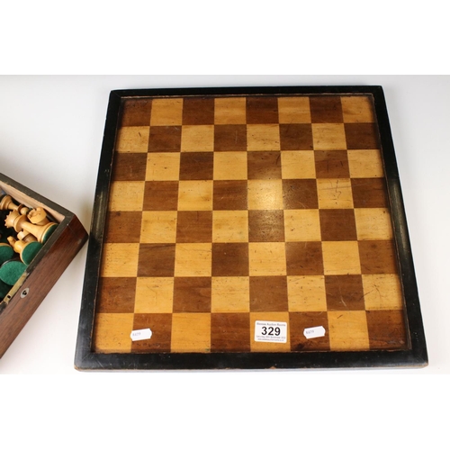 329 - A wooden chess set, in the style of Staunton, within a wooden box together with a wooden chess board... 