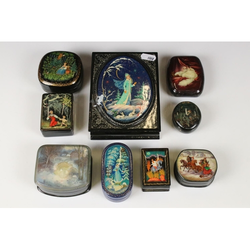 342 - A collection of nine Russian lacquerware trinket boxes with traditional decorative scenes.