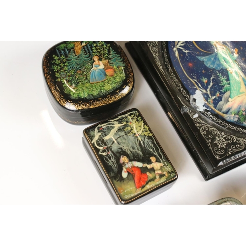 342 - A collection of nine Russian lacquerware trinket boxes with traditional decorative scenes.