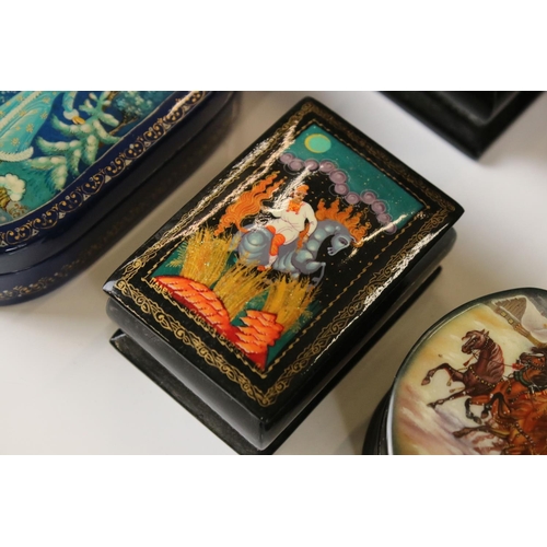 342 - A collection of nine Russian lacquerware trinket boxes with traditional decorative scenes.