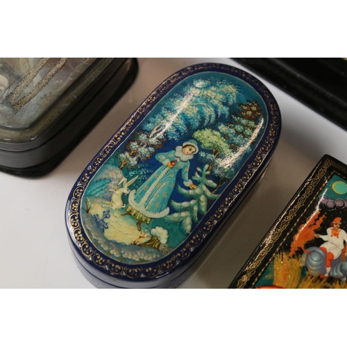 342 - A collection of nine Russian lacquerware trinket boxes with traditional decorative scenes.