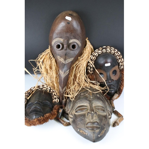 463 - Two African Tribal Ivory Coast Wooden Dan Masks with Cowrie Shell decoration, 28cm high together wit... 