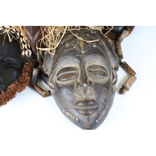 463 - Two African Tribal Ivory Coast Wooden Dan Masks with Cowrie Shell decoration, 28cm high together wit... 