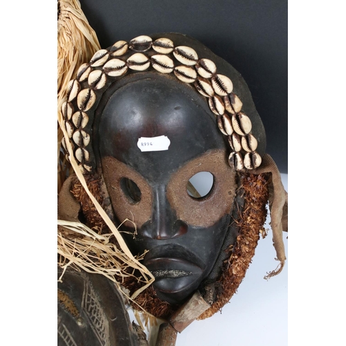 463 - Two African Tribal Ivory Coast Wooden Dan Masks with Cowrie Shell decoration, 28cm high together wit... 