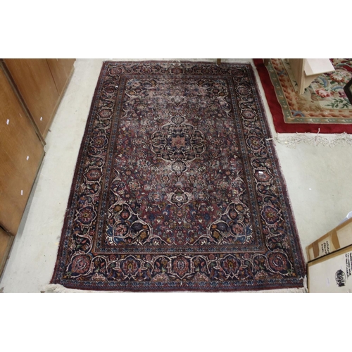 617 - Maroon Ground Wool Rug decorated with a stylised floral design within a border, 185cm x 125cm