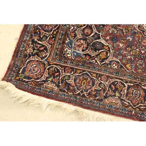 617 - Maroon Ground Wool Rug decorated with a stylised floral design within a border, 185cm x 125cm