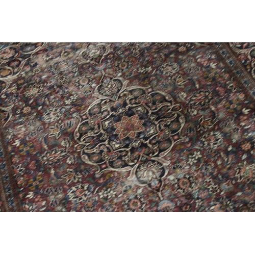 617 - Maroon Ground Wool Rug decorated with a stylised floral design within a border, 185cm x 125cm