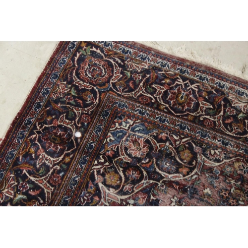 617 - Maroon Ground Wool Rug decorated with a stylised floral design within a border, 185cm x 125cm