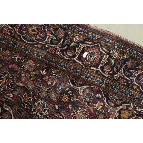 617 - Maroon Ground Wool Rug decorated with a stylised floral design within a border, 185cm x 125cm