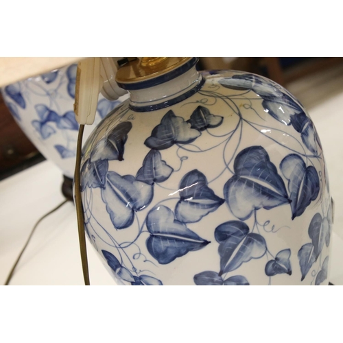 128 - Pair of Blue and White Ceramic Baluster Double Branch Table Lamps decorated with leaves, 66cm high, ... 