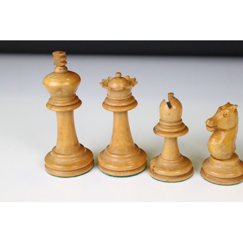 329 - A wooden chess set, in the style of Staunton, within a wooden box together with a wooden chess board... 