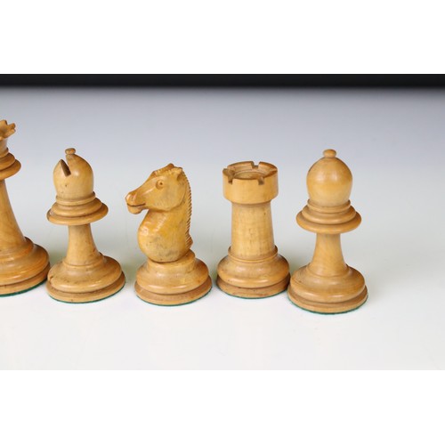 329 - A wooden chess set, in the style of Staunton, within a wooden box together with a wooden chess board... 