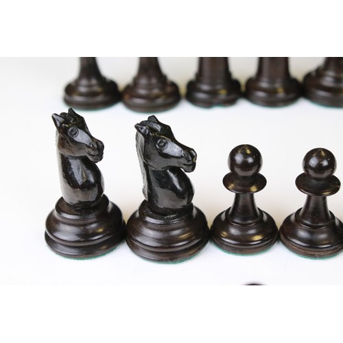 329 - A wooden chess set, in the style of Staunton, within a wooden box together with a wooden chess board... 