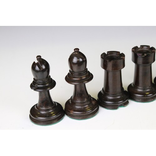 329 - A wooden chess set, in the style of Staunton, within a wooden box together with a wooden chess board... 