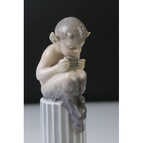 3 - Two Royal Copenhagen porcelain figures to include a faun playing a mouth organ seated on fluted colu... 