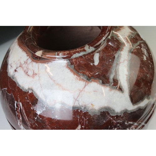 128 - Polished marble vase of spherical footed form, with tones of red and off-white, moulded rim and doub... 