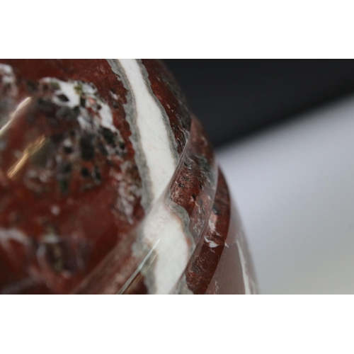 128 - Polished marble vase of spherical footed form, with tones of red and off-white, moulded rim and doub... 
