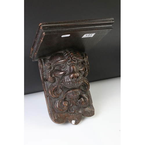 131 - Antique carved oak wall bracket in the form of a lion mask, with square shelf, approx 28cm high