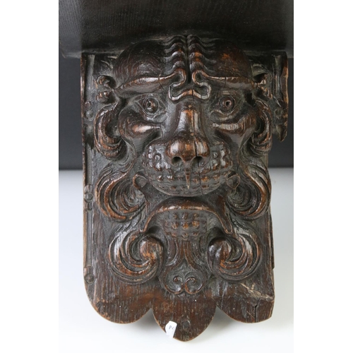 131 - Antique carved oak wall bracket in the form of a lion mask, with square shelf, approx 28cm high
