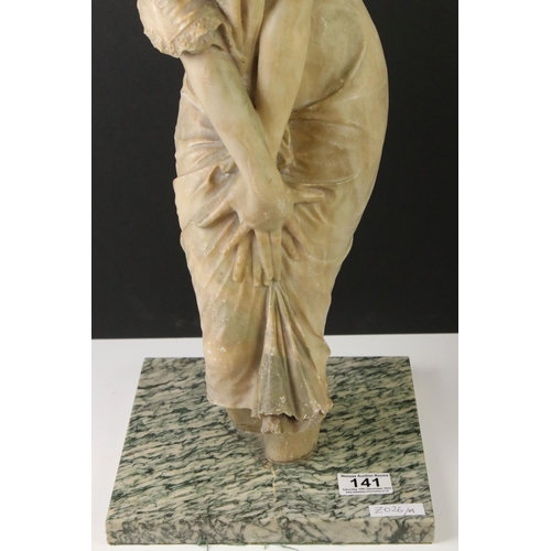 141 - Art Nouveau alabaster figure of a classical maiden, loosely dressed, mounted on a green polished sto... 