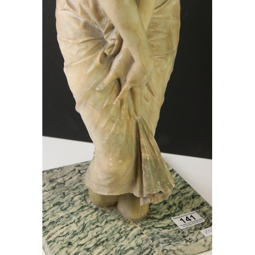 141 - Art Nouveau alabaster figure of a classical maiden, loosely dressed, mounted on a green polished sto... 