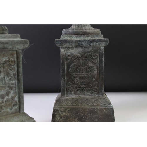 145 - Pair of bronze twin-handled urns mounted on square spelter columns with relief cast scrolling and fo... 