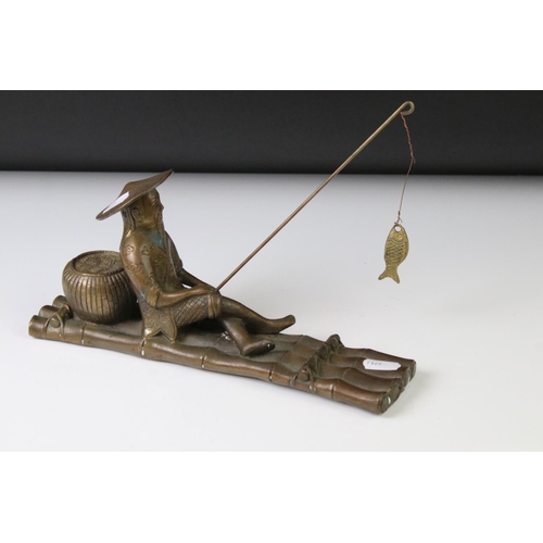 150 - Chinese bronze figure of a fisherman on a bamboo raft, with rod in hand, measures approx 28cm long