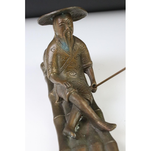 150 - Chinese bronze figure of a fisherman on a bamboo raft, with rod in hand, measures approx 28cm long