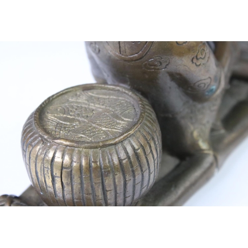 150 - Chinese bronze figure of a fisherman on a bamboo raft, with rod in hand, measures approx 28cm long
