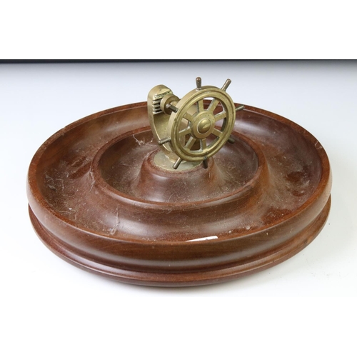 175 - Novelty turned wooden nut dish mounted with a brass ship's wheel nutcracker, approx 29cm diameter