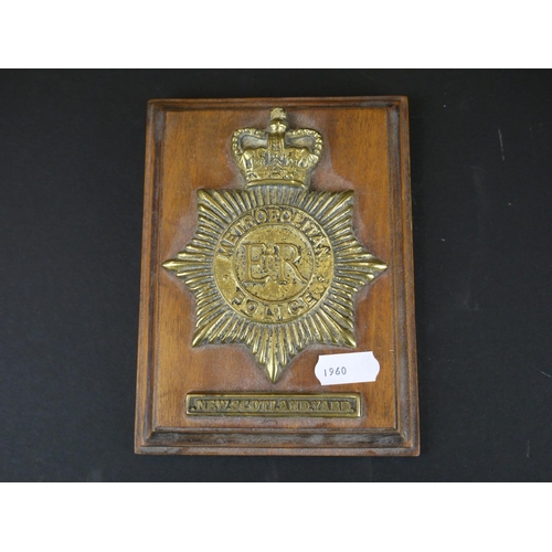 279 - A brass Metropolitan police New Scotland Yard badge on wooden wall plaque.