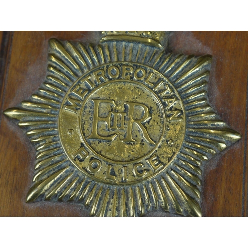 279 - A brass Metropolitan police New Scotland Yard badge on wooden wall plaque.