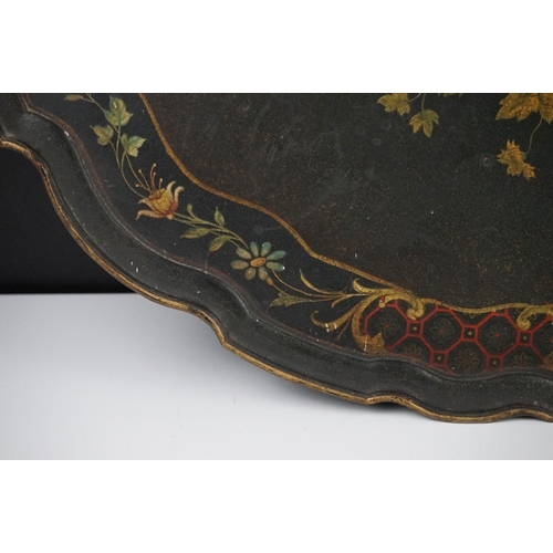 86 - Black Lacquered Papier Mache Oval Tray with shaped edge decorated with flowers, 52cm long